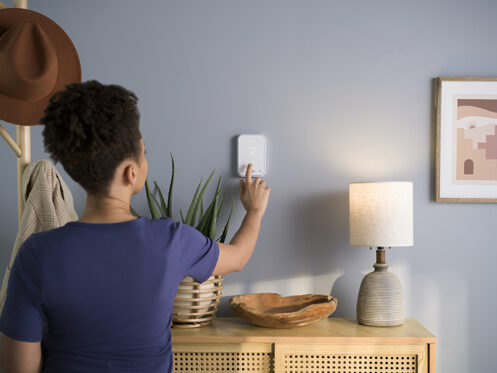 A woman setting her thermostat in Anaheim, CA